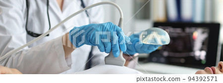 Doctor holding implant and doing ultrasound examination of woman breasts closeup Doctor holding implant and doing ultrasound examination of woman breasts closeup 94392571