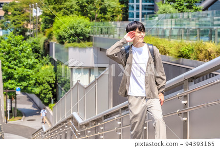 一位身著辦公室休閒服的年輕商人,在新橋站前擦汗 一位身著辦公室休閒服的年輕商人,在新橋站前擦汗 94393165