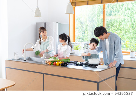 Family of four cooking in the kitchen 94395587