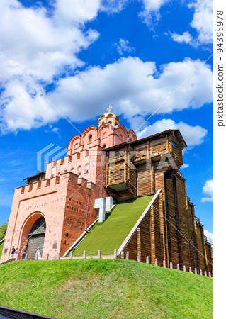 The majestic Golden Gate in the center of Kyiv on a summer day against a blue sky and white clouds. August 21, 2022 Kyiv, Ukraine. 94395978