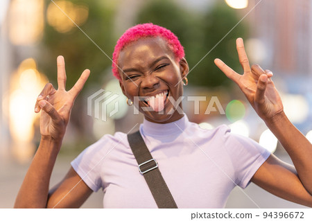 Afro woman raising the fingers gesturing victory Afro woman raising the fingers gesturing victory 94396672