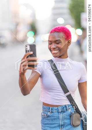 African woman with pink hair taking a selfie 94396674