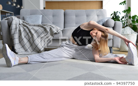 Woman doing stretching exercise at home. 94397750