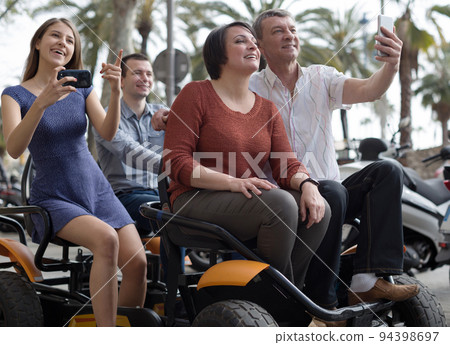 family of tourists enjoy a walk on the bike carriage 94398697