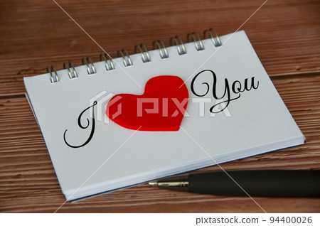I love you text on notepad with wooden cover and pen background. Romance and relationship concept 94400026