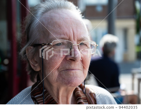 Portrait of a 84 yo grandmother looking with a serious expression Portrait of a 84 yo grandmother looking with a serious expression 94402035