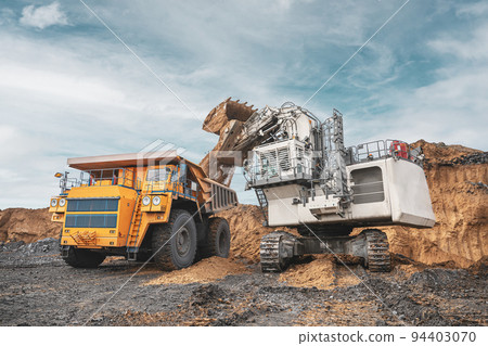 Large quarry dump truck and excavator. Big mining truck work coal deposit. Loading coal into body truck. Production useful minerals. Mining mining machinery to transport coal from open-pit production 94403070