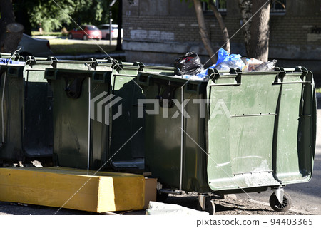Garbage cans in the urban area and a landfill. Plastic garbage containers in the village. Garbage cans in the urban area and a landfill. Plastic garbage containers in the village. 94403365