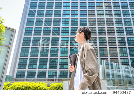 Office casual young businessman holding a laptop 94403487