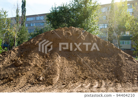A large mountain of sand in the center of the city brought to repair the road A large mountain of sand in the center of the city brought to repair the road 94404210