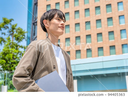 Office casual young businessman holding a laptop Office casual young businessman holding a laptop 94405363