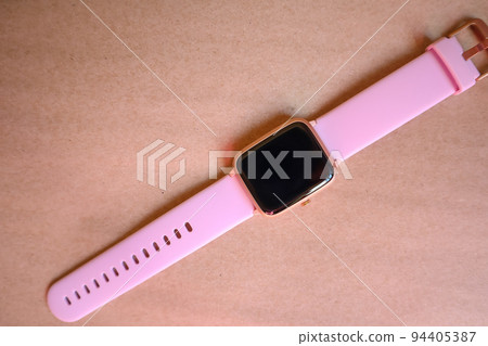 Wireless Smart Watch with Pink Strap Isolated on Brown kraft Paper Background 94405387