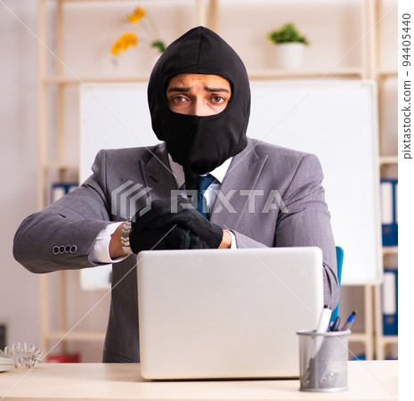 Male gangster stealing information from the office 94405440