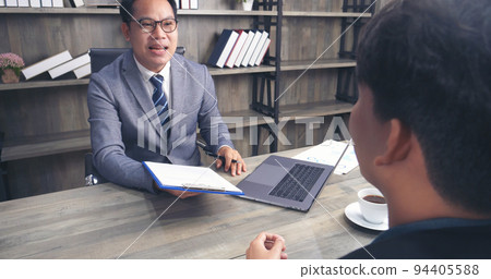 Businessman job interview by human resource HR officer interviwing, talk new employee shaking hands in office with smiling face. HR Manager interview check resume, face to face. Job Interview Concept Businessman job interview by human resource HR officer interviwing, talk new employee shaking hands in office with smiling face. HR Manager interview check resume, face to face. Job Interview Concept 94405588