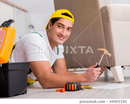 Furniture repairman repairing armchair at home Furniture repairman repairing armchair at home 94405595