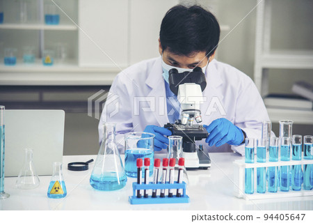 Scientist man look into Microscope research in science laboratory. Asian scientist looking equipment laboratory chemistry labs. Covid-19 coronavirus biochemistry research experiment vaccine concept Scientist man look into Microscope research in science laboratory. Asian scientist looking equipment laboratory chemistry labs. Covid-19 coronavirus biochemistry research experiment vaccine concept 94405647