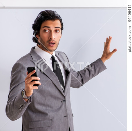 Young handsome businessman in front of whiteboard Young handsome businessman in front of whiteboard 94406415