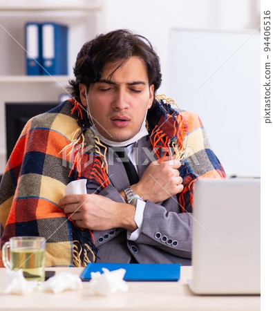 Man with flu working in the office 94406516