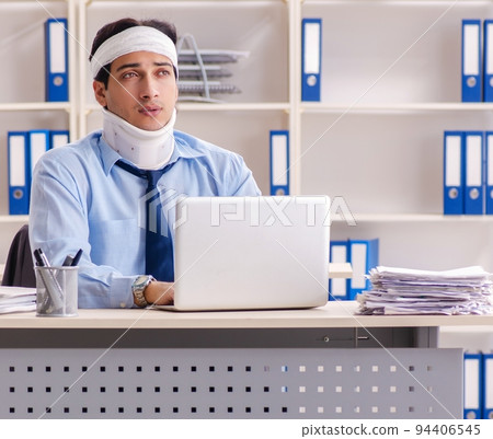 Young injured male employee working in the office Young injured male employee working in the office 94406545