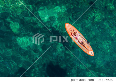 Young women Having Fun Stand Up Paddling in blue water sea in Montenegro. SUP. girl Training on Paddle Board near the rocks Portrait of a disgruntled girl sitting at a cafe table 94406680
