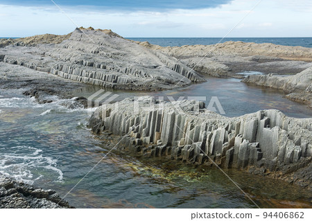 coastal cliffs formed by columnar basalt at low tide coastal cliffs formed by columnar basalt at low tide 94406862