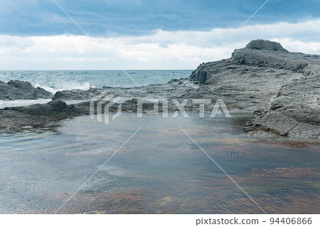 coastal cliffs formed by columnar basalt at low tide coastal cliffs formed by columnar basalt at low tide 94406866