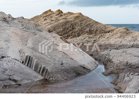 coastal cliffs formed by columnar basalt at low tide coastal cliffs formed by columnar basalt at low tide 94406923