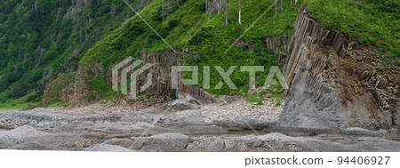 coastal landscape, beautiful wooded rocks on the green coast of Kunashir island 94406927