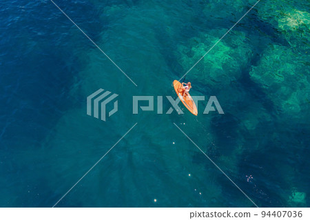 Young women Having Fun Stand Up Paddling in blue water sea in Montenegro. SUP. girl Training on Paddle Board near the rocks Portrait of a disgruntled girl sitting at a cafe table 94407036