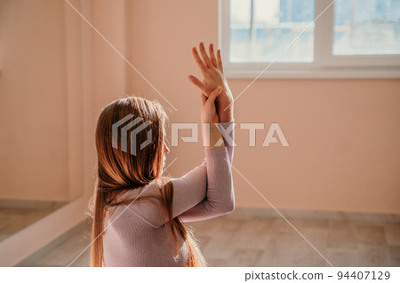 View from above. A beautiful young woman in pink sportswear is engaged in yoga, sports in the hall on a purple rug. Yoga, sport and healthy concept. 94407129