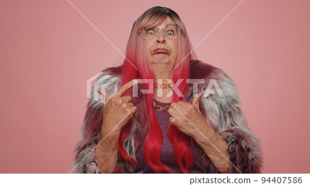 Funny joyful senior grandmother making playful silly facial expressions, grimacing, fooling around Funny joyful senior grandmother making playful silly facial expressions, grimacing, fooling around 94407586