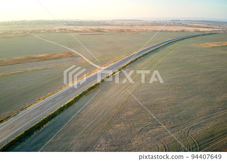 Aerial view of empty intercity road at sunset. Top view from drone of highway in evening Aerial view of empty intercity road at sunset. Top view from drone of highway in evening 94407649