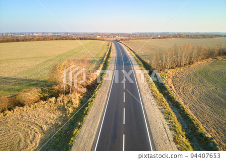 Aerial view of empty intercity road at sunset. Top view from drone of highway in evening Aerial view of empty intercity road at sunset. Top view from drone of highway in evening 94407653