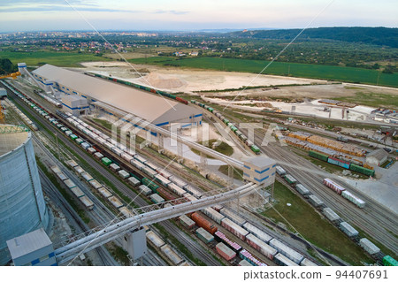 Aerial view of cargo train cars loaded with construction goods at mining factory. Railway transportation of industrial production raw materials Aerial view of cargo train cars loaded with construction goods at mining factory. Railway transportation of industrial production raw materials 94407691