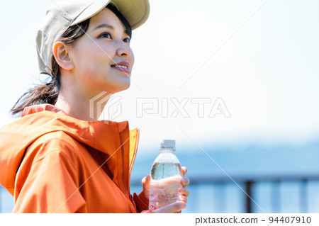 Young woman with plastic bottle for hydration Young woman with plastic bottle for hydration 94407910
