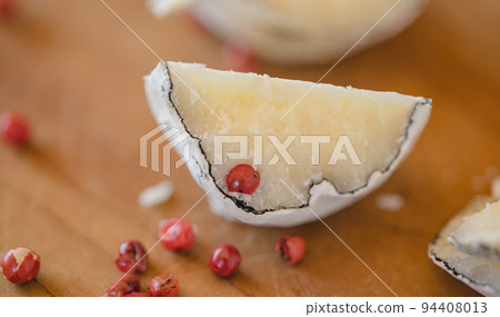 Belper knole with garlic and pink pepper in wood ash. Close-up view. Selective focus. 94408013