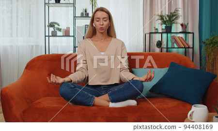 Woman breathes deeply with mudra gesture, eyes closed meditating with concentrated thoughts peaceful 94408169