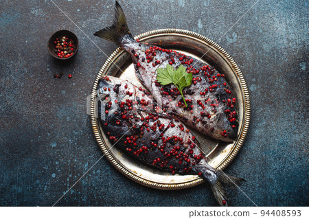 Raw fish dorado with pink peppercorn for healthy cooking top view 94408593