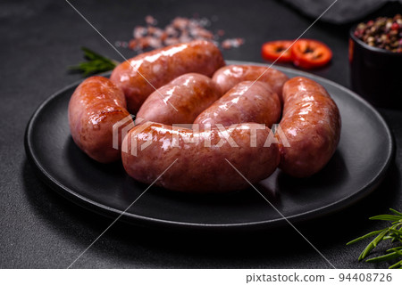 Grilled sausages with spices and herbs on a black background Grilled sausages with spices and herbs on a black background 94408726