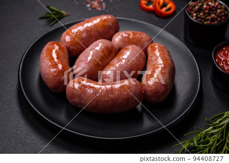 Grilled sausages with spices and herbs on a black background Grilled sausages with spices and herbs on a black background 94408727