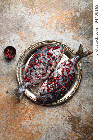 Raw fish dorado stuffed with vegetables for healthy cooking top view Raw fish dorado stuffed with vegetables for healthy cooking top view 94409165