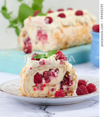 Baked meringue roll with cream and fresh red raspberry, white background. Baked meringue roll with cream and fresh red raspberry, white background. 94409295