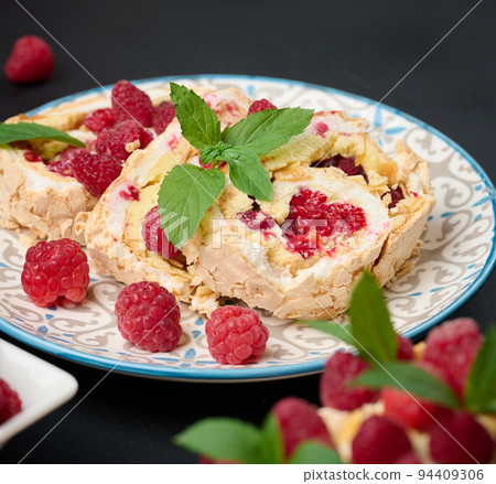 Baked meringue roll with cream and fresh red raspberry 94409306