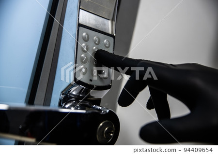 Thief in black gloves tries to enter the code 94409654