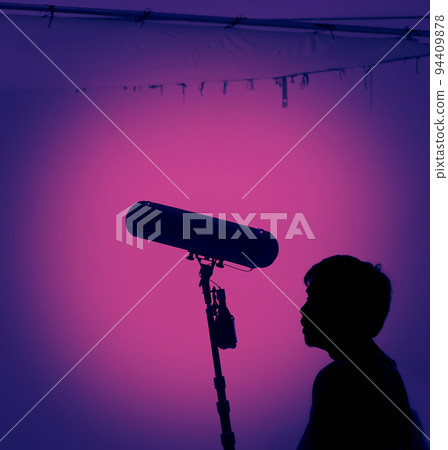 Boom Microphone for sound recording in film industry. Sound boom operator recording sound by microphone fisher for movie set in studio. Boom mic holds up high by video or film production crew team man Boom Microphone for sound recording in film industry. Sound boom operator recording sound by microphone fisher for movie set in studio. Boom mic holds up high by video or film production crew team man 94409878