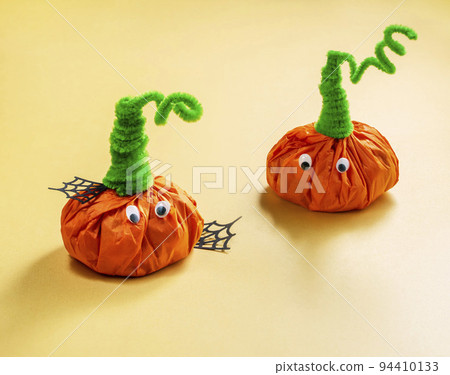halloween treats for kids wrapped in the shape of pumpkins. Party favor bag with colorful candy. Trick or Treat, concept for Halloween halloween treats for kids wrapped in the shape of pumpkins. Party favor bag with colorful candy. Trick or Treat, concept for Halloween 94410133