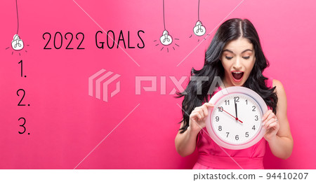 2022 goals with young woman holding a clock 2022 goals with young woman holding a clock 94410207