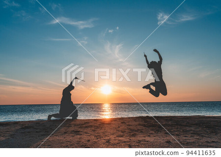 日本海夕陽下演奏剪影的男女 日本海夕陽下演奏剪影的男女 94411635