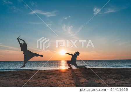 Men and women playing silhouettes at sunset in the Sea of Japan Men and women playing silhouettes at sunset in the Sea of Japan 94411636