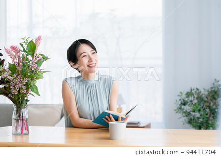 在客廳裡看書的中年女人 94411704
